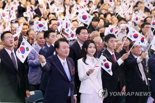윤석열 대통령과 김건희 여사가 15일 서울 서대문구 이화여대 대강당에서 열린 제78주년 광복절 경축식에서 만세삼창을 한 뒤 태극기를 흔들고 있다. 대통령실통신사진기자단